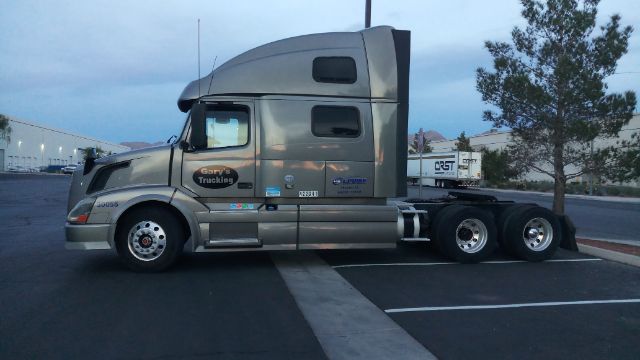 Volvo 780 conventional sleeper truck side profile with silver paint and multiple decals.