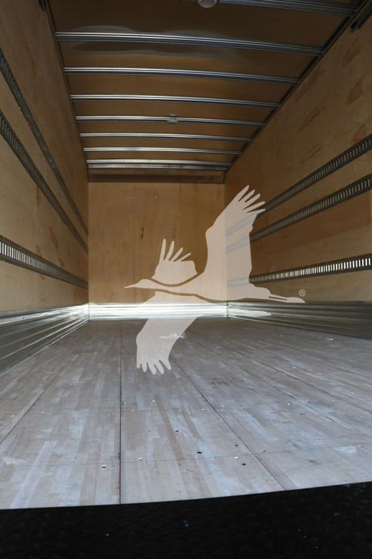 Isuzu box truck interior showing empty cargo area with wooden walls and metal rails.