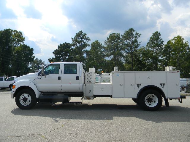 Truck setup: 2011 Ford F-750 Super Duty Crew Cab service/utility chassis with utility boxes and compartments along the bed.