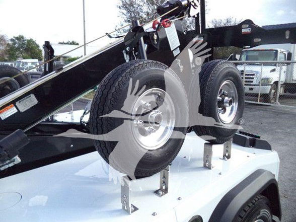 Truck bed with dual spare tires mounted on a white utility chassis; visible labels and hardware on metal brackets.