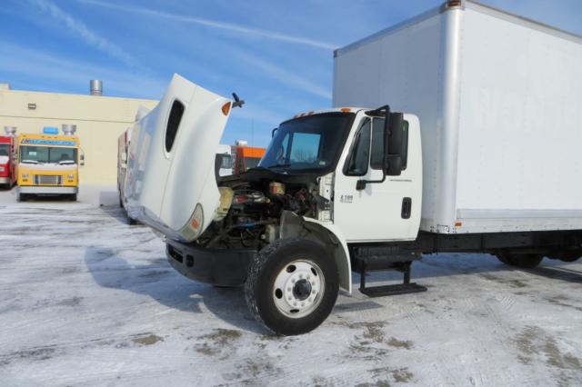 International 4300 box truck with hood open, exposing engine bay. white cab, cargo box, snow on ground.