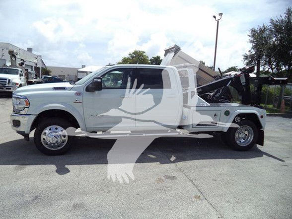 Tow truck with a Ram 5500 chassis and a dump bed, white color, side profile view.