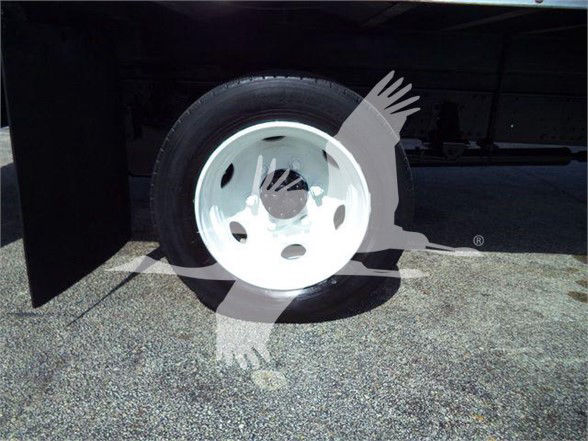 Isuzu truck wheel and fender with white rim, partial undercarriage visible.