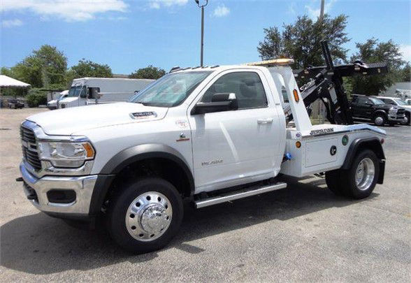 Ram 4500 tow truck in white with a wheel-lift on the back, side view showing cab and towing equipment.