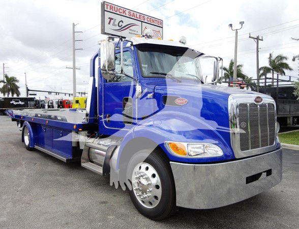 Peterbilt 337 tow truck in blue, front-left view with chrome grille and bumper.