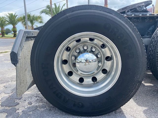 Truck wheel with shiny chrome hubcap and Goodyear tire on a Mack CXU613 conventional sleeper truck.