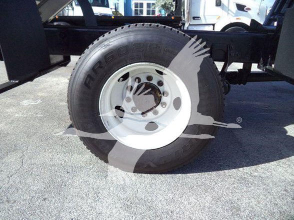 Wheel and tire on aCommercial truck chassis showing white steel rim and Bridgestone tire with part of the chassis visible.