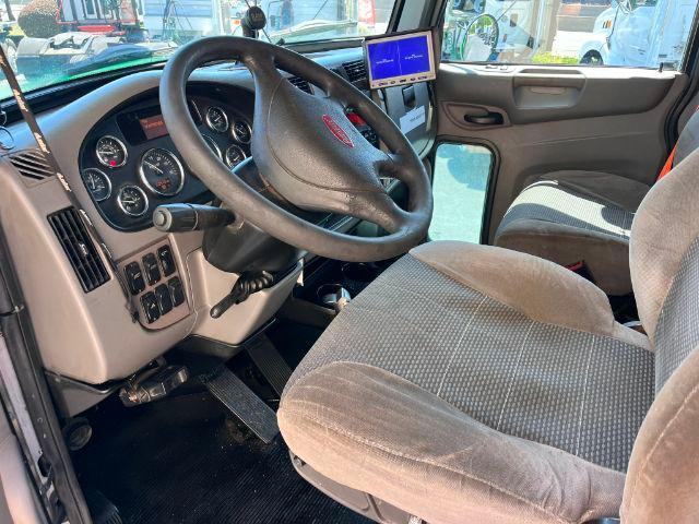 Cab interior of a 2015 Peterbilt 348 showing steering wheel, gauge cluster, and driver's seat.