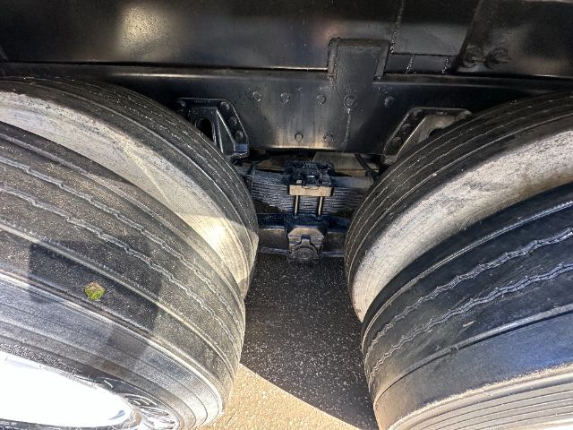 Image of a vehicle drive area showing dual rear axles with large tires and suspension components.