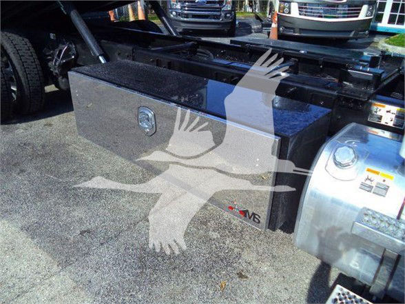 Peterbilt 536 truck chassis showing a rectangular aluminum toolbox mounted behind the cab with a lock and badge, adjacent to fuel tank.