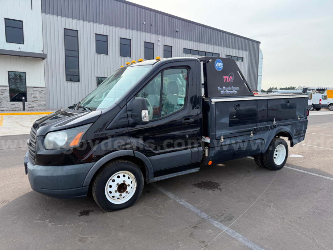 Ford Transit utility truck with service toolbox in bed, black exterior, white steel wheels, side doors and work decals visible.