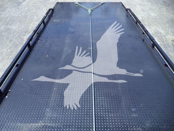 Tow truck flatbed with Diamond Plate surface and a logo of a flying bird overlapping the bed.