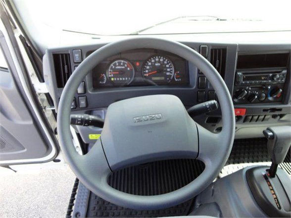 Isuzu NPR HD truck steering wheel and dashboard with gauges visible in cab interior.