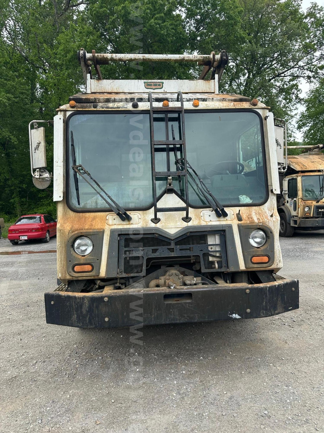 Front view of a 2017 Mack MRU613 garbage truck showing large front bumper, dual windshield wipers, and a raised spreader mechanism on top.