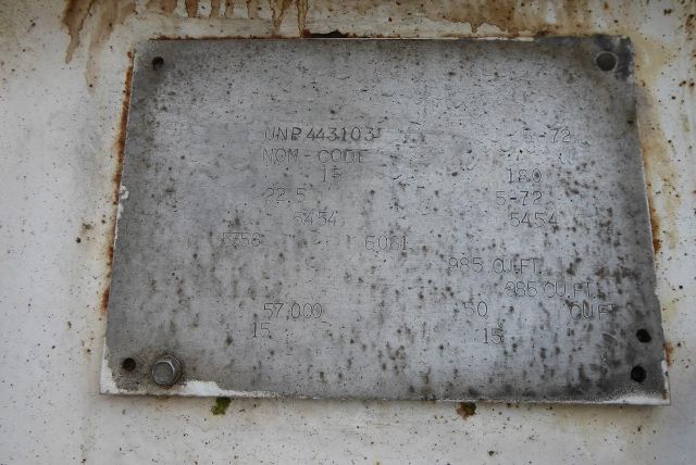 Metal identification plate on Fruehauf dry bulk trailer with stamped text: UNR 443103? NOM CODE? 18? 1? 225? 5454? 57,000 15? 150? 985 CU FT.