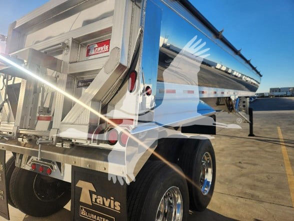 Dump trailer side and rear showing Travis logo, chrome wheels, and aluminum dump body with hydraulic ramp. VIN 48XFF3920S1018249, stock 392504.