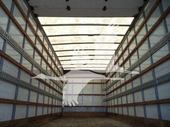 Interior of a box truck trailer showing wooden and metal side walls with overhead ribs and a faded floor.