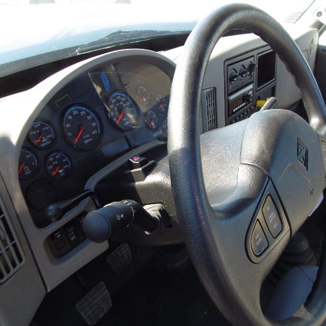 Dashboard and steering wheel of a 2016 International 7400 SBA 6x4 truck cab interior showing gauges and steering column.