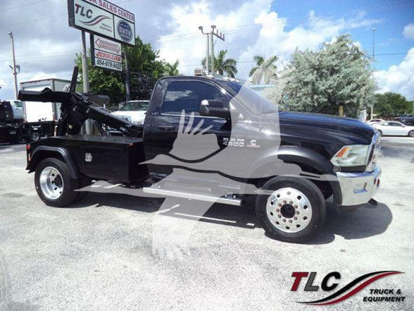 2018 Ram 4500 SLT tow truck with a black body and flatbed, side view in a dealership lot. Visible text on signs in background and a TLC Truck & Equipment watermark.