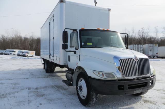 International 4300 box truck in a snowy lot showing cab and cargo box with large front grille.