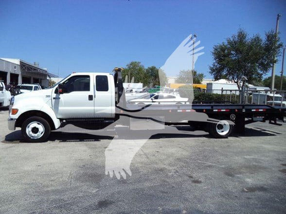 2015 Ford F650 XLT tow truck side view showing long flatbed and dual rear wheels.