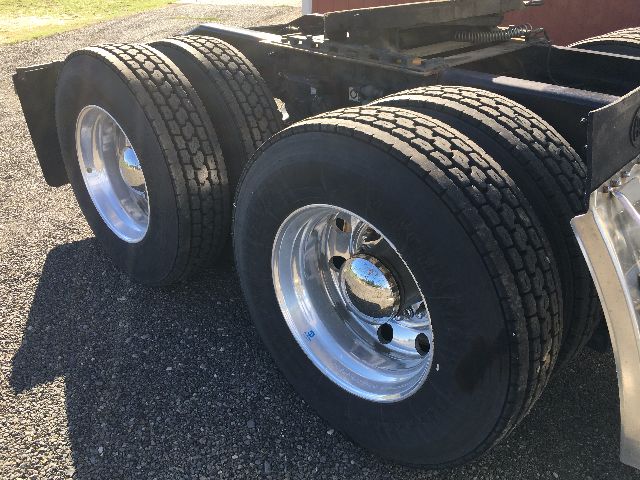 Peterbilt 578 truck chassis rear dual axle wheels with black tires and polished aluminum rims.