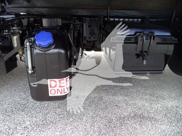 Isuzu NPR HD engine bay with coolant reservoir and fuse/relay box visible