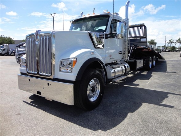Kenworth W900 tow truck in a bright chrome configuration visible from the front-left side.