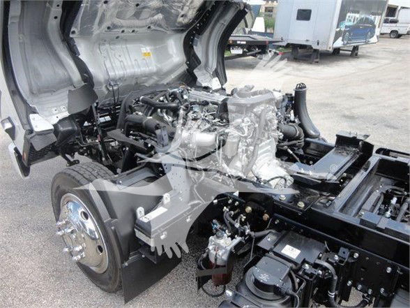 Isuzu NRR truck chassis and engine bay with open cab side showing engine block and components.