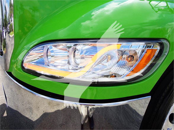 Front left headlight Area of a bright green 2022 Peterbilt 337 truck.