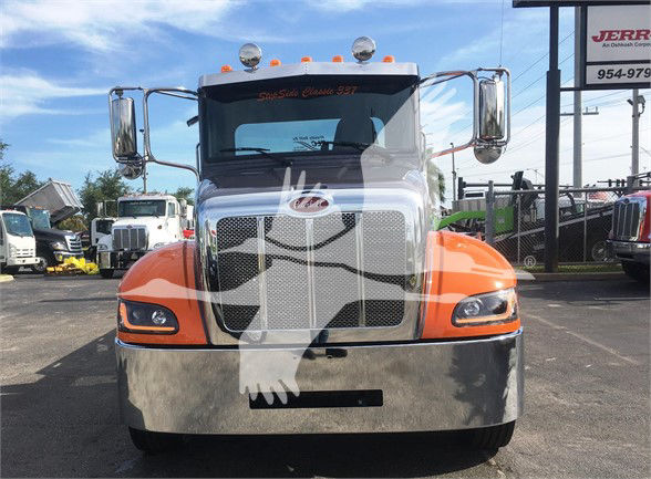 Front view of a 2022 Peterbilt 337 tow truck with orange fenders, chrome grille, and large side mirrors.