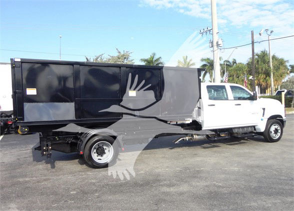 2023 Chevrolet Silverado 5500HD heavy-duty refuse truck side view showing black refuse body and white cab.
