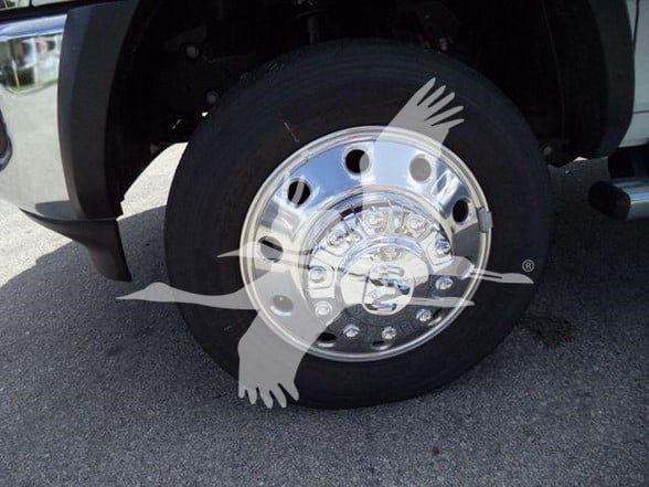 Ram 5500 wheel with polished chrome hubcap and tire, front left side view.