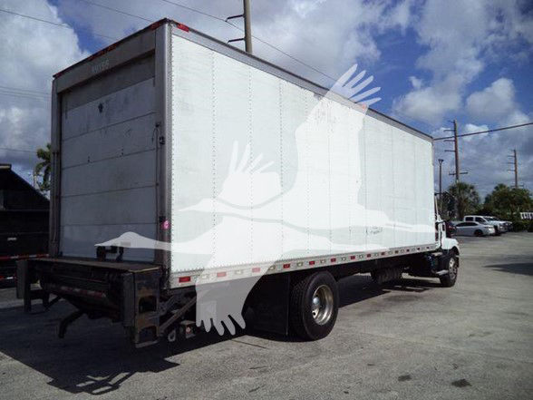 Truck with a box trailer in an open lot showing a large white cargo box.