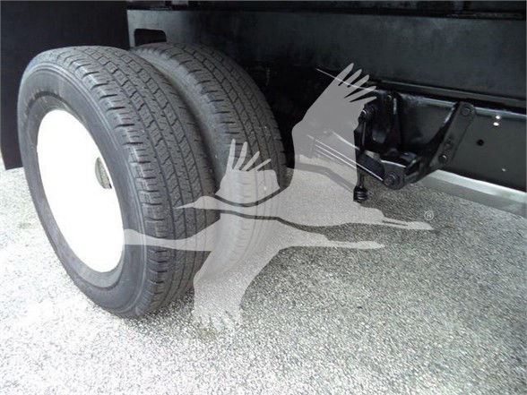 Ford E-450 chassis showing dual rear wheels and undercarriage with suspension components.
