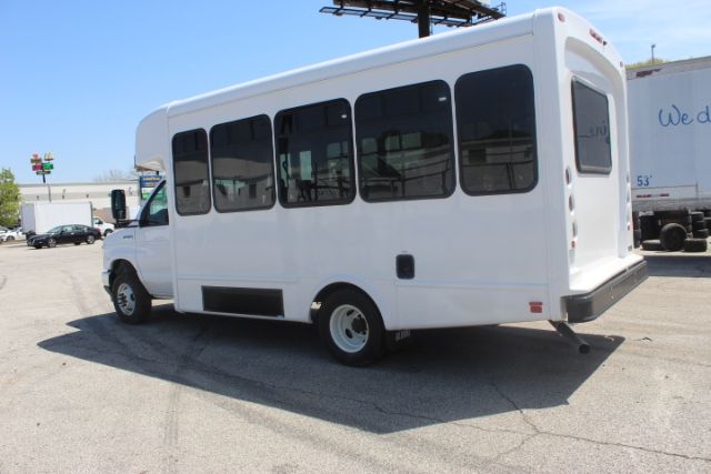 Ford E450 shuttle bus white exterior side view showing windows and rear entry step, stock number 258001JH notations.