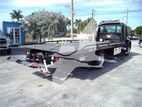 Kenworth T280 tow truck flatbed chassis view showing flatbed, wheel arches, and rear ramps.