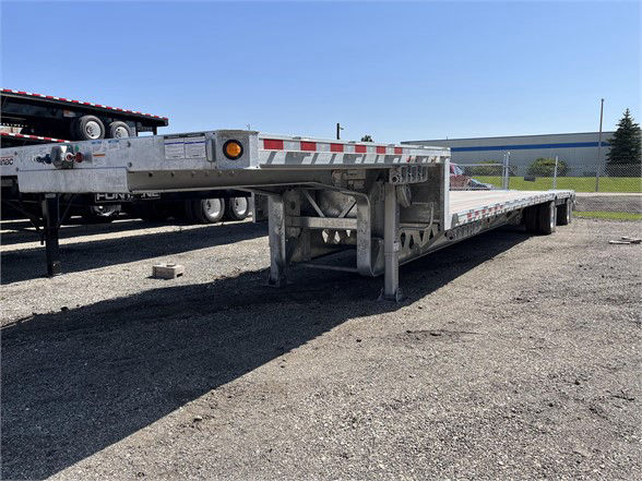Manac steel drop deck trailer side view showing deck, undercarriage, and support structure.