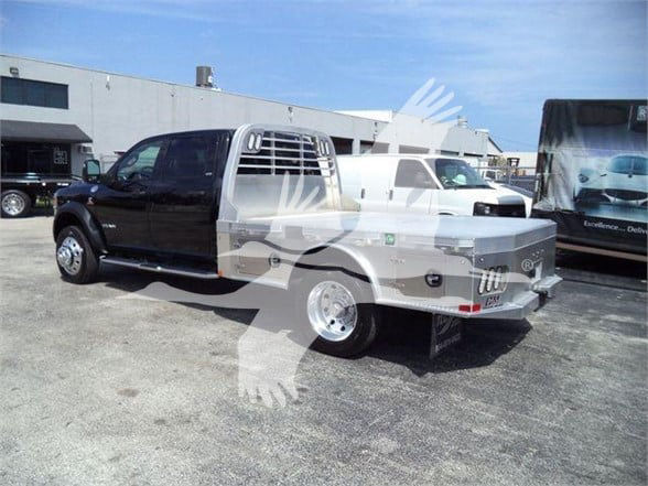 Truck bed and cab with dual-tone black and silver Ram 5500 SLT, with chrome wheels and utility bed. Visible text on truck includes no legible brand markings beyond Ram styling.