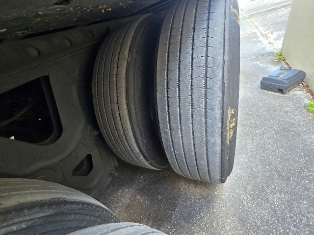 Two truck trailer tires and undercarriage showing the wheel assembly and suspension components.