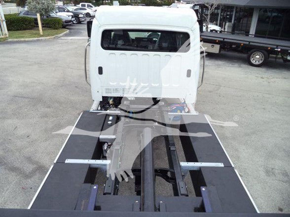 Freightliner Business Class M2 106 chassis with flatbed/loader setup viewed from rear of cab.
