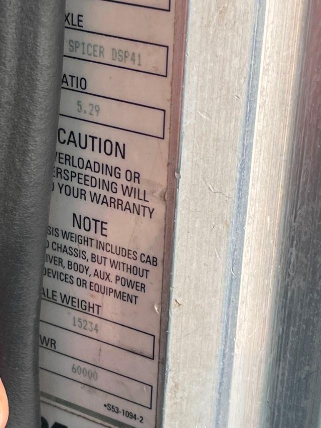 Label on truck showing SPICER DSP41 and weight/caution text, with partial VIN plate and door edge.