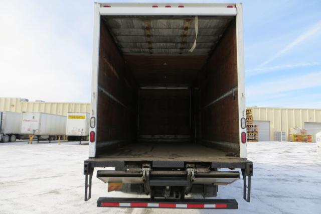 Box truck rear with empty cargo area, International 4300, metal interior walls, open doors, tailgate and rear bumper visible.