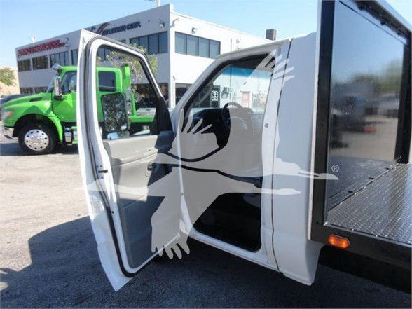 Ford E-Series 2011 flatbed truck with front passenger door open, showing interior and flatbed tail area.