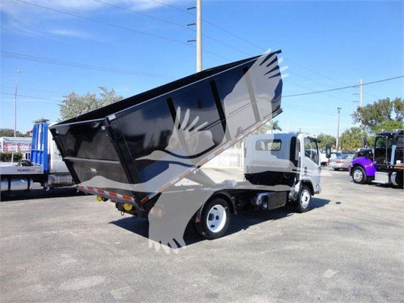 Isuzu NRR dump truck in service showing a tilted black dump bed and white cab, medium-duty chassis, used condition.