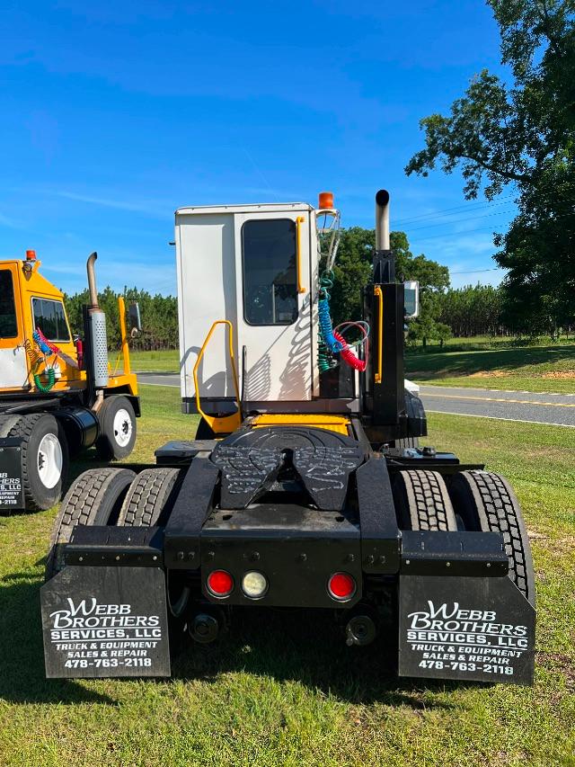Back view of a 2016 Kalmar Ottawa YT30 yard truck with black rear frame, dual rear axles, white cab, orange beacon, and WebB Brothers Services mudflaps.