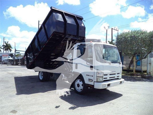 Isuzu NRR dump truck with elevated black dump bed in a parking lot.