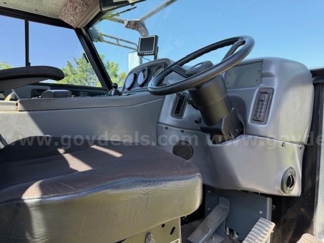 Interior of 2010 Elgin Pelican NP sweeper truck cab with steering wheel, dashboard, and driver seat visible.