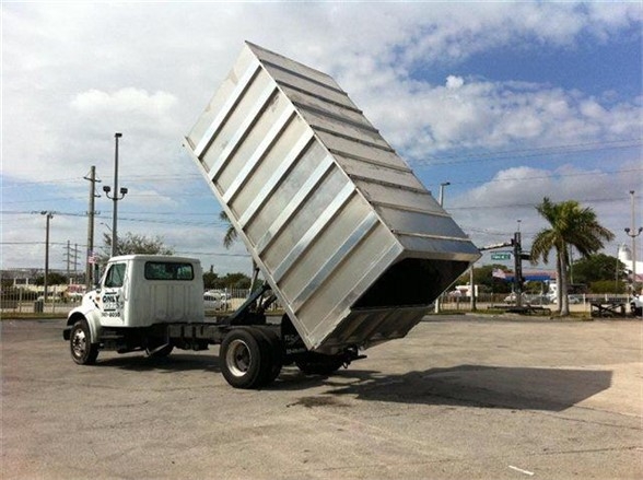 Dump truck with a raised 16 ft aluminum dump body on a white cab truck, stock number 16CH72A, in a parking lot.