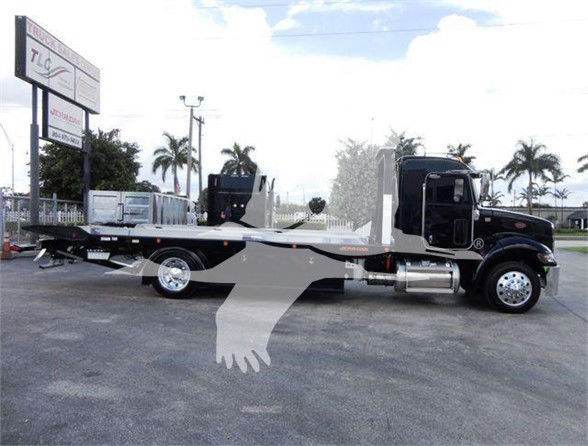 2022 Peterbilt 337 tow/truck on a lot with a long flatbed carrier.